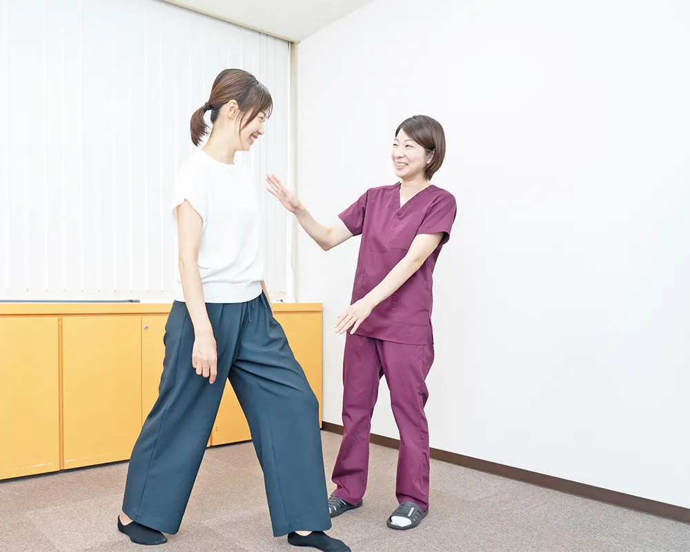 整体師から姿勢トレーニングを受ける女性