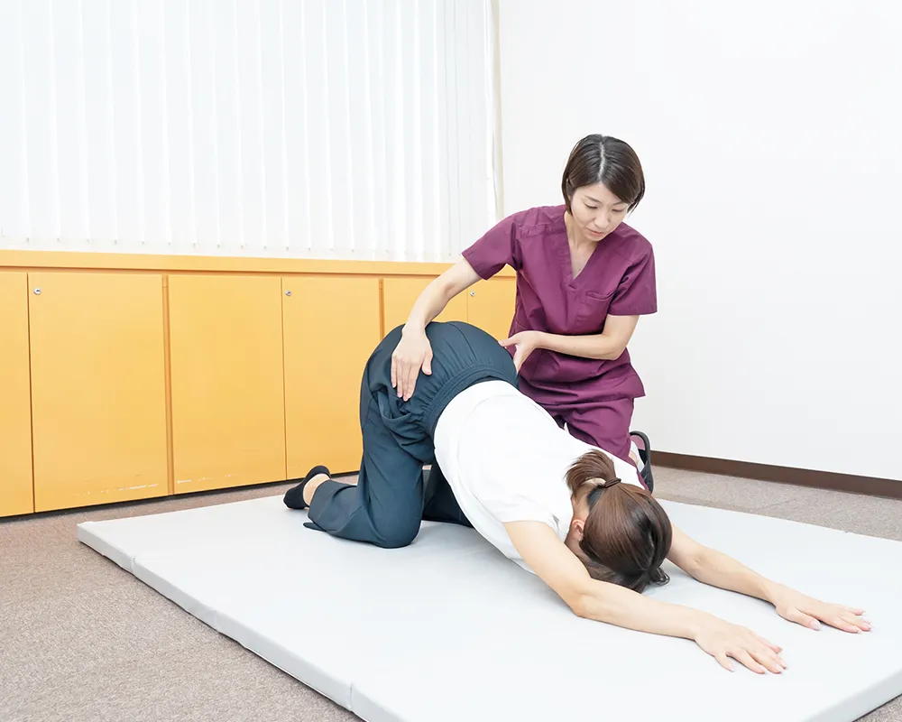 整体師からストレッチトレーニングを受ける女性