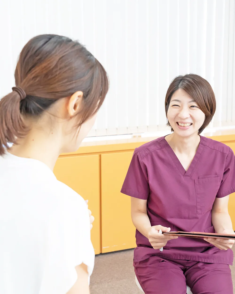 女性から説明を聞いている整体師