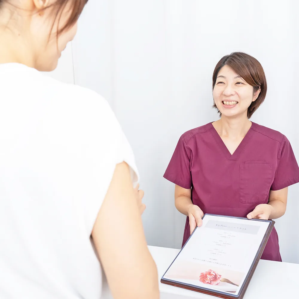 次回の予約を確認している整体師