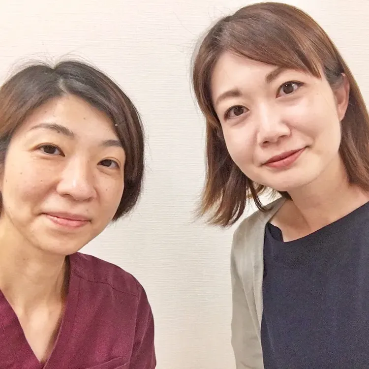 症状が改善した女性と並ぶ整体師