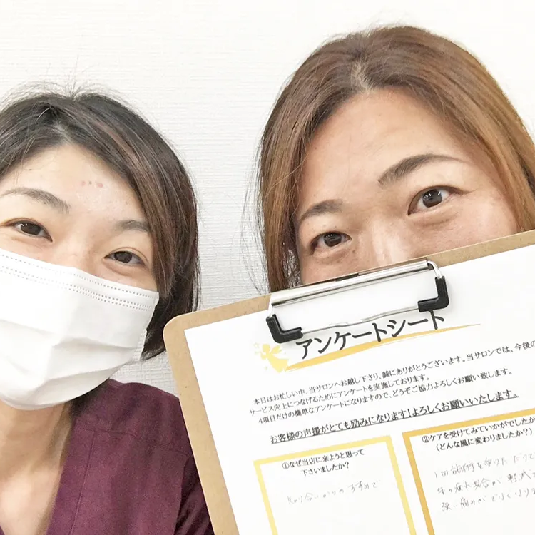 症状が改善した女性と並ぶ整体師